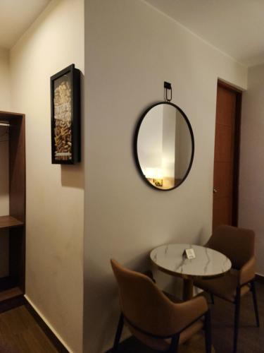 a room with a table and chairs and a mirror at Hotel Alba in Ica