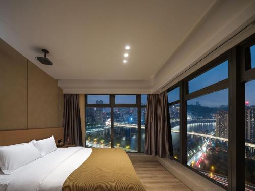 a hotel room with a bed and a large window at Ouchen International High altitude Cloud River View Hotel Chongqing Guanyinqiao Beibin 1st Road in Chongqing