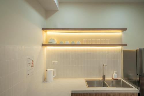 a kitchen with a sink and a refrigerator at Tobe in Hue 1 - Cozy Apartment with Pool and Gym & City View in Thôn Văn Dương