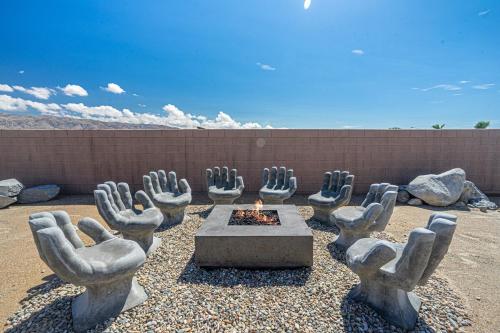 a group of statues of hands around a fire pit at Desert Picasso! Pool, Spa, Games, Mountain Views in Desert Hot Springs