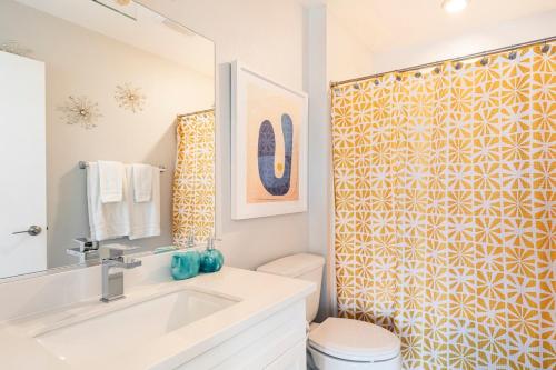 a bathroom with a sink and a toilet and a shower at Desert Picasso! Pool, Spa, Games, Mountain Views in Desert Hot Springs