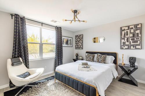 a bedroom with a bed and a chair at Desert Picasso! Pool, Spa, Games, Mountain Views in Desert Hot Springs