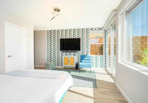 a bedroom with a bed and a tv on a wall at Desert Picasso! Pool, Spa, Games, Mountain Views in Desert Hot Springs