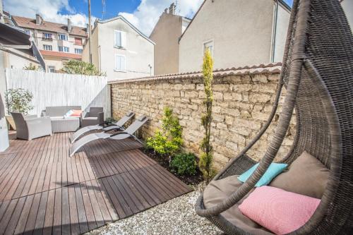 - un hamac sur une terrasse en face d'un bâtiment dans l'établissement Suite and Spa 21, à Dijon