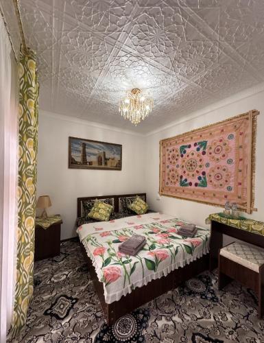 a bedroom with a bed and a chandelier at Zardozon Hotel in Bukhara