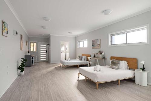 a bedroom with two beds and a living room at Comfort Stay - Detached Quadruple Studio Room with Simple Kitchenette near Top Ryde city in Sydney