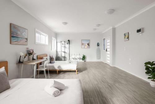 a white room with a bed and a desk at Comfort Stay - Detached Quadruple Studio Room with Simple Kitchenette near Top Ryde city in Sydney