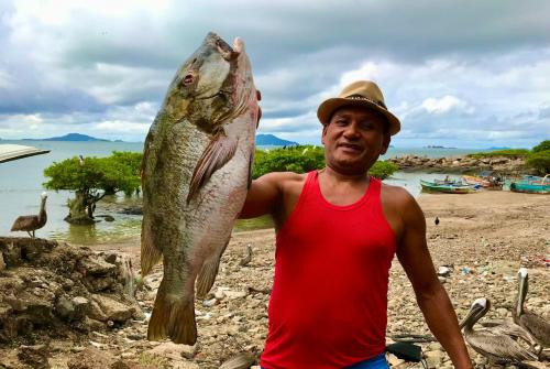 a man holding a fish in his hand at Apartamento de lujo arriba de la playa con acceso directo al mar in Veracruz