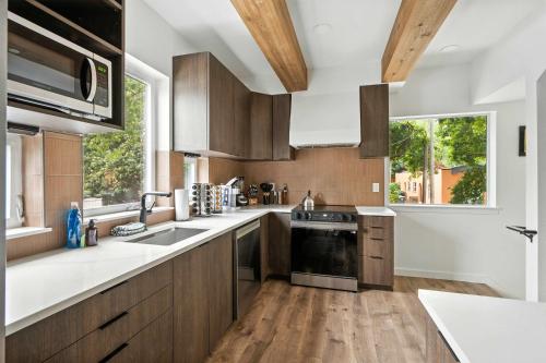 a kitchen with wooden cabinets and a large window at The Adelynn - 5BR Luxury in Walkable Portland in Portland