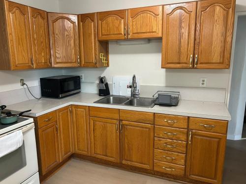 a kitchen with wooden cabinets and a sink at Cottages by Storybook Park in Burley