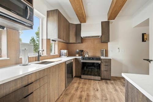 ポートランドにあるThe Adelynn - 5BR Modern Luxury - Central Spotの木製のキャビネットと大きな窓のあるキッチン