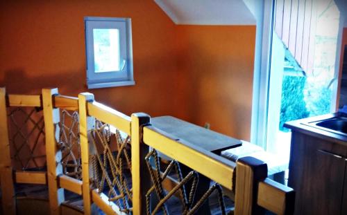 a wooden table in a kitchen with a window at Mieszkanko Nad Śliwką in Stronie Śląskie