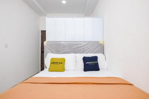 two pillows sitting on a bed in a room at Urbanview Tiana Residence Nagoya Batam by Reddoorz in Nagoya