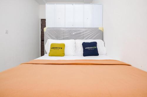 two pillows sitting on a bed in a room at Urbanview Tiana Residence Nagoya Batam by Reddoorz in Nagoya