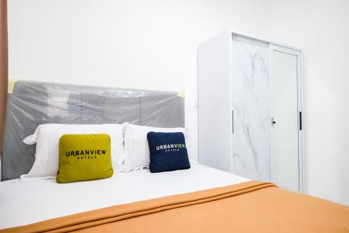 two pillows sitting on top of a bed at Urbanview Tiana Residence Nagoya Batam by Reddoorz in Nagoya