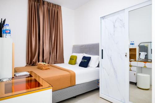 a bedroom with a bed and a glass door at Urbanview Tiana Residence Nagoya Batam by Reddoorz in Nagoya