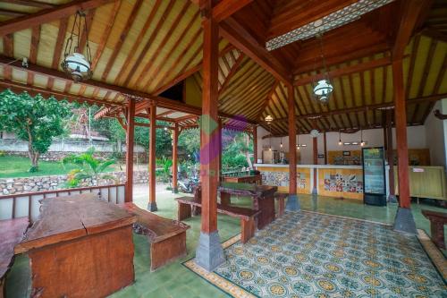 an inside view of a building with benches and tables at Arys Lagoon Bungalow & Hotel in Karimunjawa