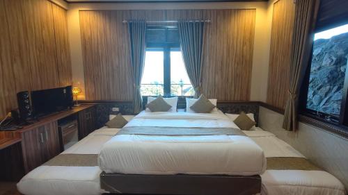 two beds in a hotel room with a window at Qion's Villa in Cibogo