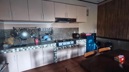 a kitchen with white cabinets and a stove at Qion's Villa in Cibogo
