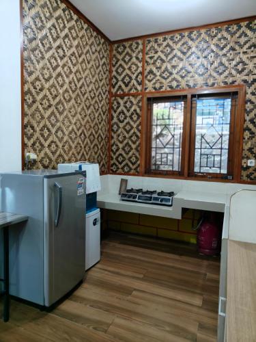a kitchen with a stove and a refrigerator at Qion's Villa in Cibogo