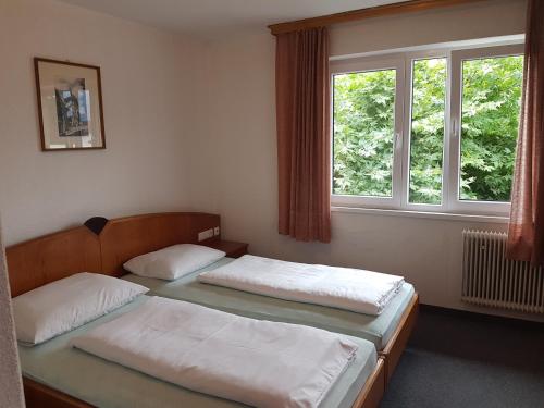 2 Betten in einem Zimmer mit 2 Fenstern in der Unterkunft Gasthaus Krone in Koblach