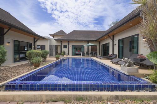 a swimming pool in the backyard of a house at Queen Palm Villa in Rawai Beach