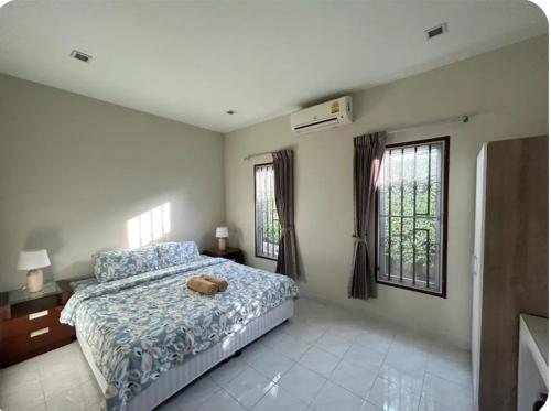 a bedroom with a bed and two windows at The Endless Bangtao Residence TV2 AND TV 3 in Bang Tao Beach