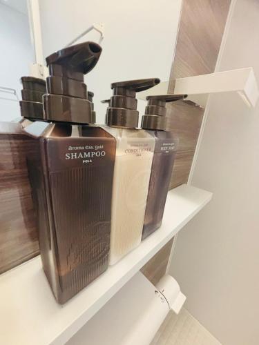 a shelf with three shampoo bottles on it at ZZOKIAI緋桜 Open in September 2025! 30-second walk to the sea!4LDK!Free parking! in Itoman