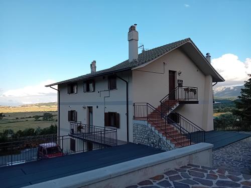 a white house with stairs on a roof at B&B Il Narciso Blu in Rocca di Cambio