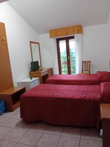 a hotel room with two beds and a window at B&B Il Narciso Blu in Rocca di Cambio
