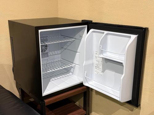 an empty refrigerator with its door open on a table at The Zen Residence Sapporo in Sapporo