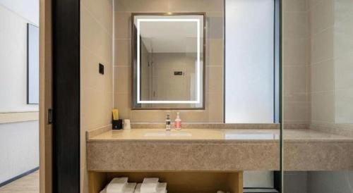 a bathroom with a sink and a mirror at City Comfort Inn Shiyan Wudang Mountain in Danjiangkou