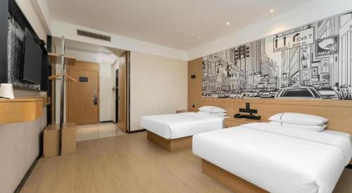 a hotel room with two beds and a tv at City Comfort Inn Shiyan Wudang Mountain in Danjiangkou