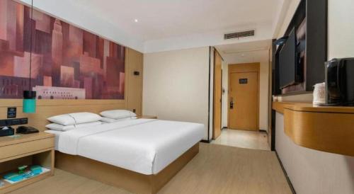 a bedroom with a white bed and a tv at City Comfort Inn Shiyan Wudang Mountain in Danjiangkou
