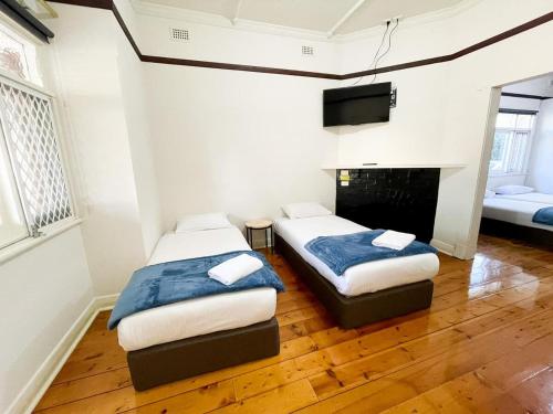 two beds in a room with a fireplace and a tv at big group house Westbourne park 