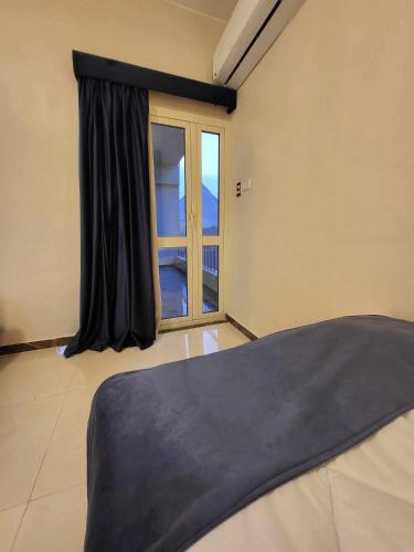a bedroom with a window and a bed with black curtains at Alaska Pyramids Hotel in Cairo