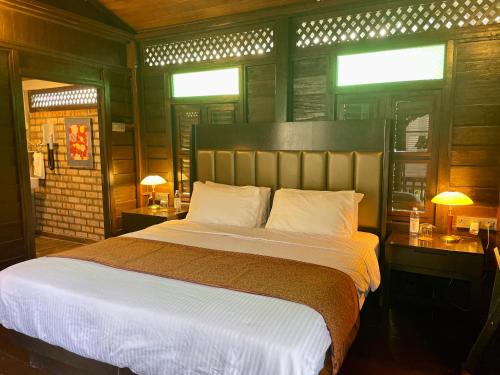 a bedroom with a large bed and two tables with lamps at Landmark Cenang in Pantai Cenang