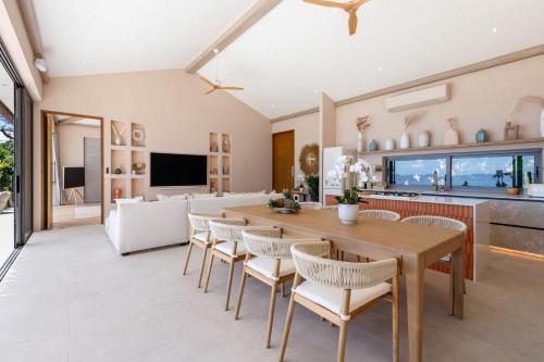 a kitchen and living room with a table and chairs at Rosa Del Mar Seaview Villa with gym in Ban Nong Chaeng