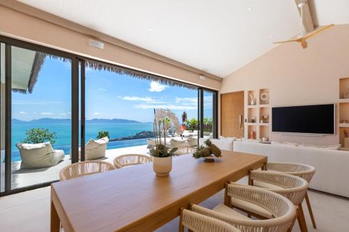 a living room with a table and chairs and a large window at Rosa Del Mar Seaview Villa with gym in Ban Nong Chaeng