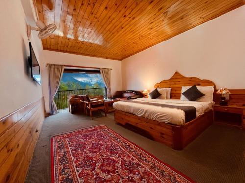 マナリにあるManali Heritage Hotel - Best Selling Hotel in Manaliのベッドと机と窓のある寝室