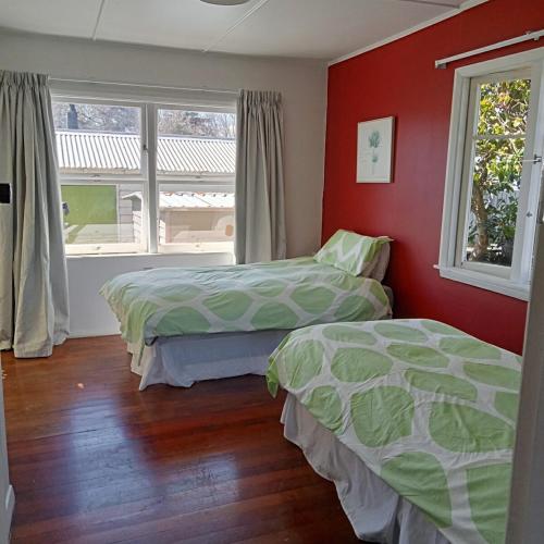 two beds in a bedroom with red walls and a window at Dated but Delightful on D'Arcy in Richmond
