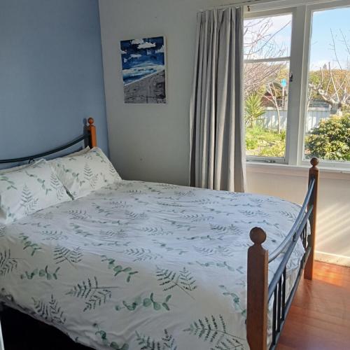 a bedroom with a bed with a blue and white comforter at Dated but Delightful on D'Arcy in Richmond