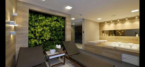 a bathroom with a green wall with a tub and a sink at Loft Alto padrão na beira mar de Tambaú in João Pessoa