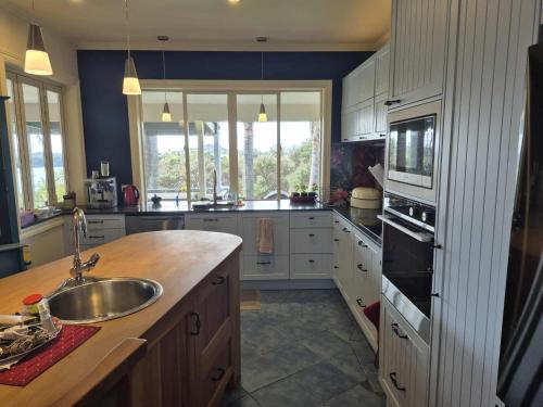 a kitchen with a sink and a counter top at Matai Whetū - Stargazer Tutukaka in Tutukaka
