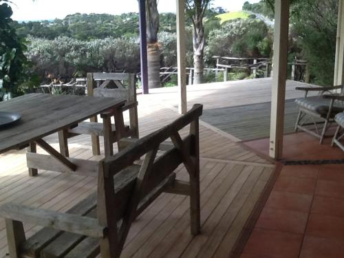a wooden table and bench on a wooden deck at Matai Whetū - Stargazer Tutukaka in Tutukaka