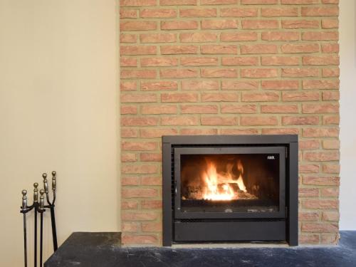 a brick fireplace with a fire in it at Holiday Home in Rogery with Sauna in Rogery