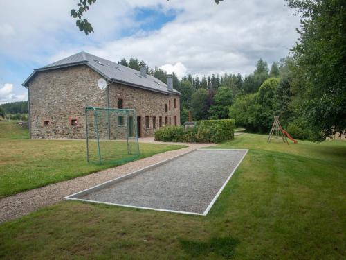 an old brick building with a playground in the yard at Holiday Home in Rogery with Sauna in Rogery