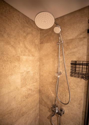 a shower with a shower head in a bathroom at Luxury Rooms in the Heart of Pyramids in Kafr Ghaţāţī