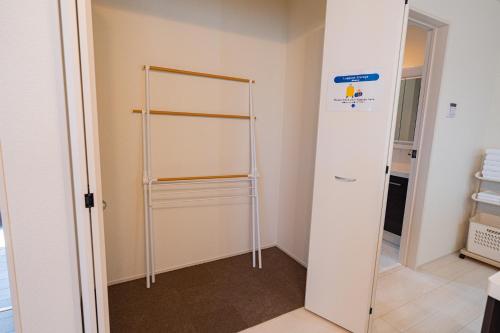 a room with a closet with a glass door at Tropical Beach Vacation House in Ginowan
