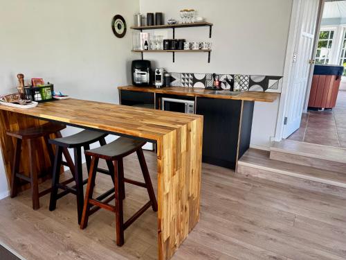 a kitchen with a wooden table and stools at The Lake House with private spa Lake Rotorua in Rotorua